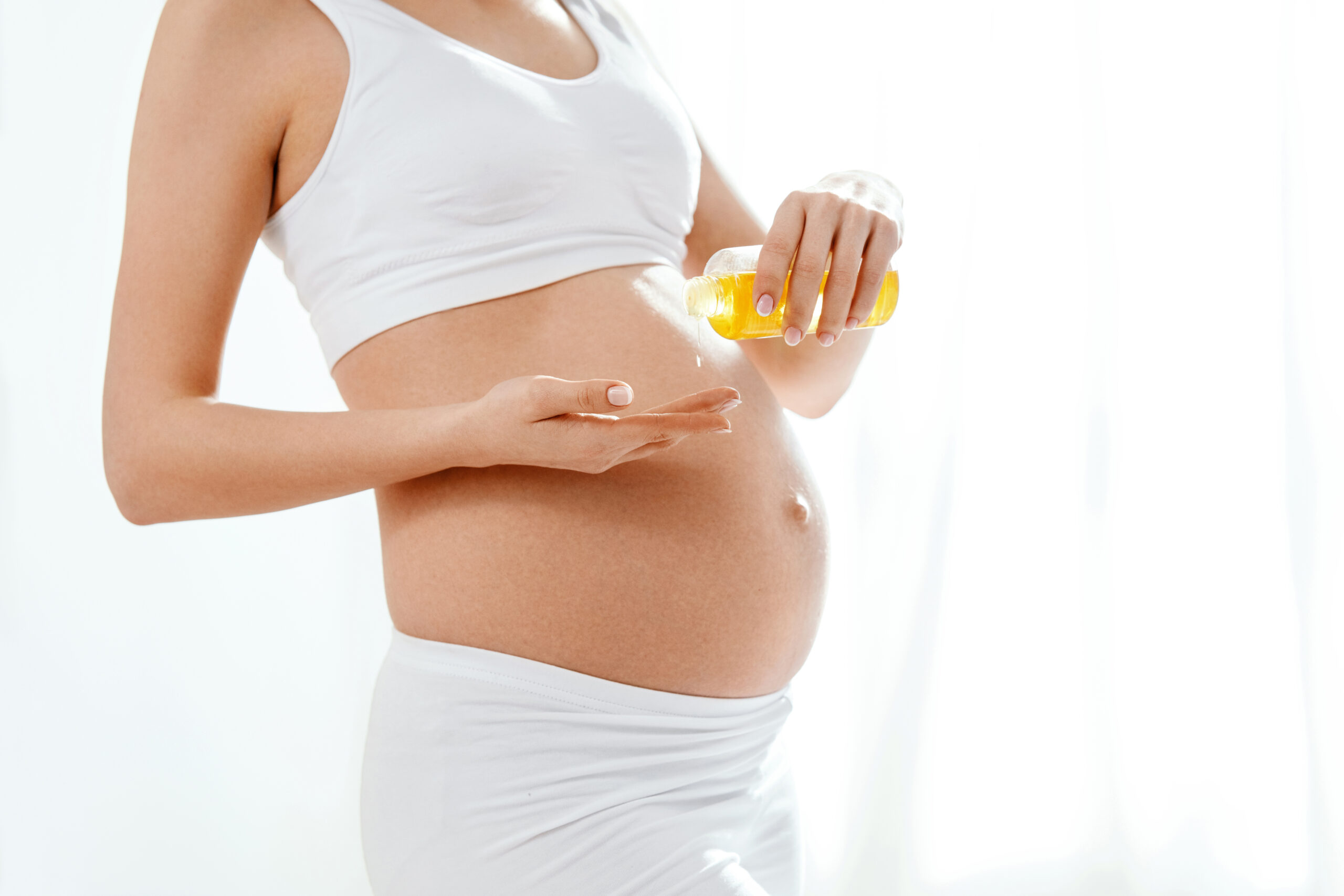 obrazok na webe Strie: Príčiny vzniku a prírodné riešenia pre krásnu pokožku Tehotná žena používa prírodný olej na prevenciu strií